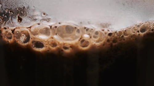 Darkly Roasted Coffee Bubbles in Glass