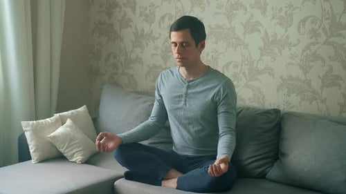 Man Meditating Quietly on Couch in Peaceful Room