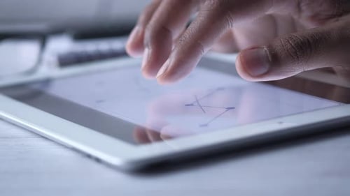 Man's Hand Working on Digital Tablet at Office Desk, Using Self Created Chart