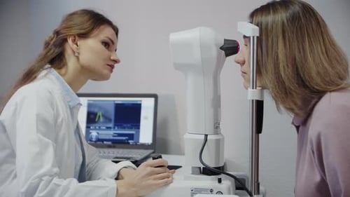 Der Augenarzt untersucht das Auge des Patienten und schaut dann in die Kamera