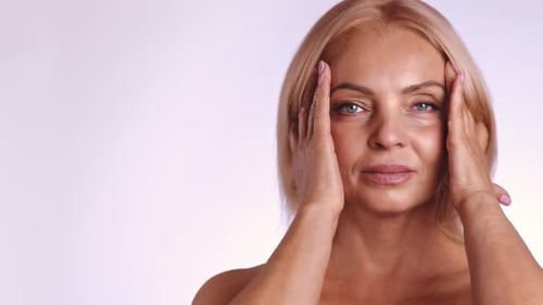 Blonde Woman Massaging Her Face in a Close Up