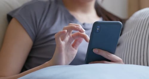 Woman Relaxing and Scrolling on Mobile Phone Indoors