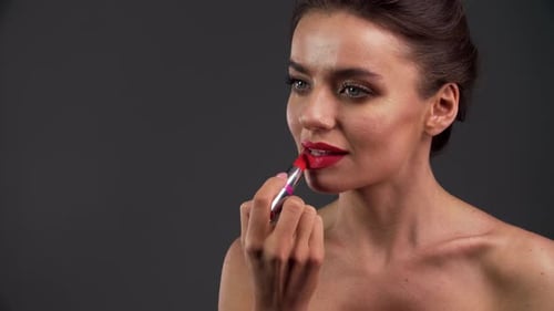 Woman Applying Red Lipstick in Close Up