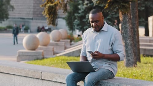 Adult Working on Laptop in Urban Park