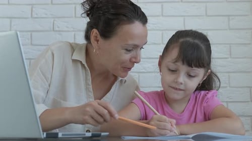 Woman helping child with homework at home