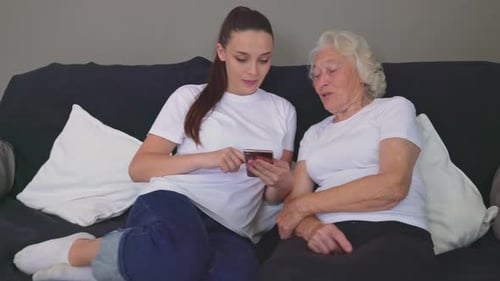 Young Woman and Senior Woman Looking at Phone