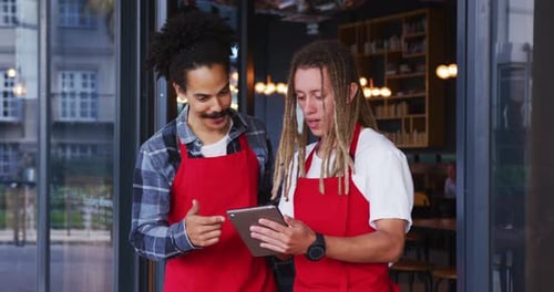Young Adults Reviewing Tablet Information in Urban Workplace