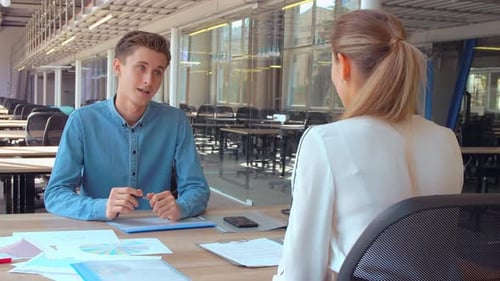 Employé assis au bureau en face du client