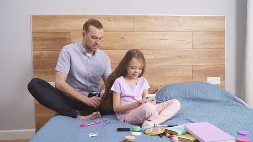 Dad Brushes Daughter's Hair As She Plays Phone