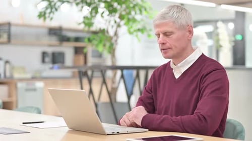 Man Works on Laptop at Modern Desk