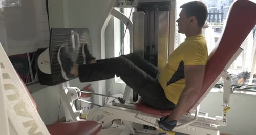 Man Working Out on Leg Press Machine in Gym