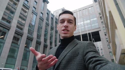 Smiling Young Business Man Making Selfie Video Call Standing Outdoor at Business District. Portrait