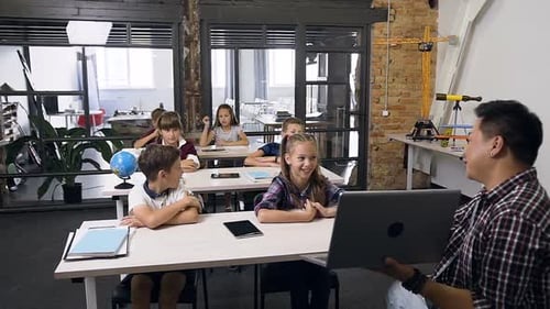 Lehrer der High School Etwas Erklärendes und Zeigen für Schüler am Laptop