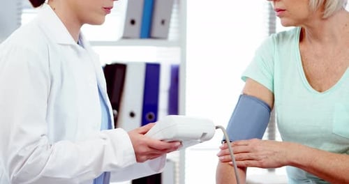 Doctor Checks Patient's Blood Pressure in Clinic