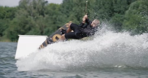 Wakeboarding in a Lake Near the Forest, Sportsman Surfs on the Water, Ride on a Wakeboarding Board