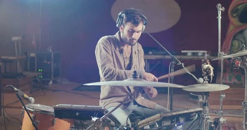 Drummer playing on electronic drum set in a recording studio