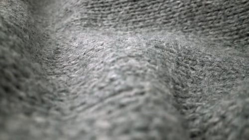 Extreme detail view of sheep wool cloth texture flowing in macro dolly shot.