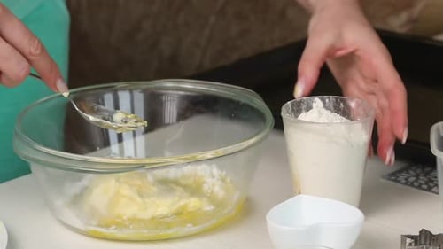 A Woman Mixes The Ingredients For Making A Biscuit In A Container.