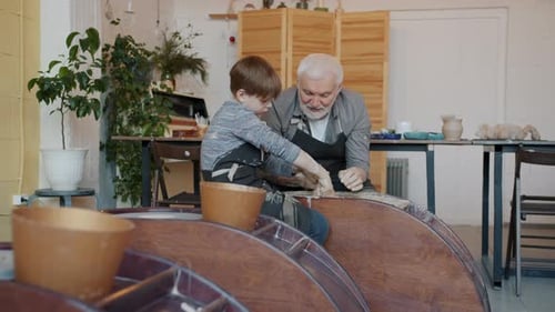 Grandfather and Grandson Making Pottery Together