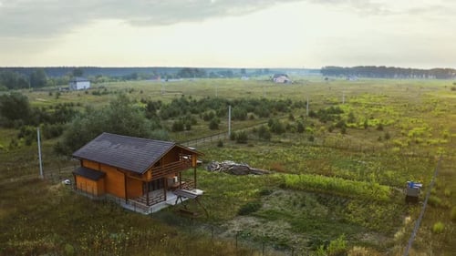 Aerial Fly Over Farm House in the Summer. Lonely Country House in the Middle of the Field. Cloudy