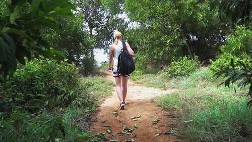 Woman Walking on Tropical Path Towards Ocean
