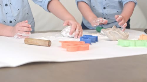 Zwei Jungen bereiten zusammen mit ihrer Mutter Teig für Kekse zu