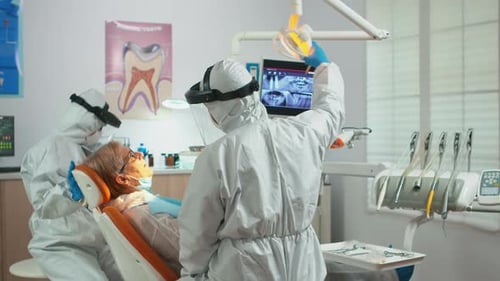 Dental Treatment by Professionals in Full Protective Gear