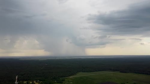 Aerial view of a distant big dark blue storm clouds forming on the horizon in summer, wide angle asc