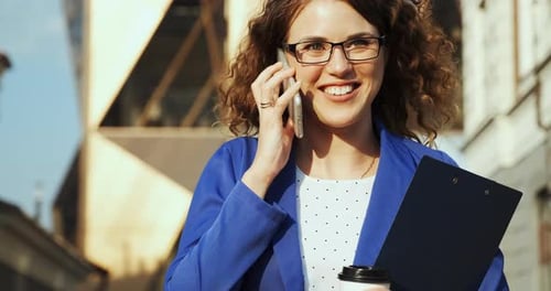 Cheerful Woman Talks on Phone in City