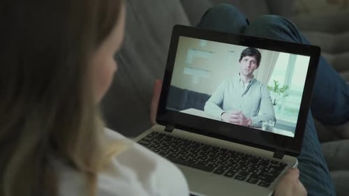 Woman Having Video Chat with Colleague at Table in Office, Closeup