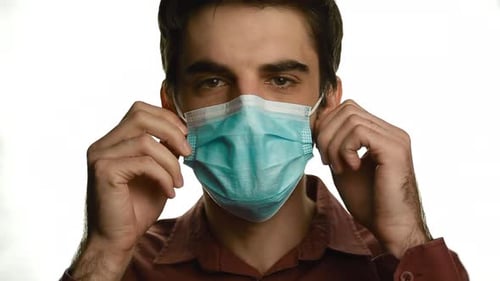 Young Adult Putting On Medical Mask, Close Up