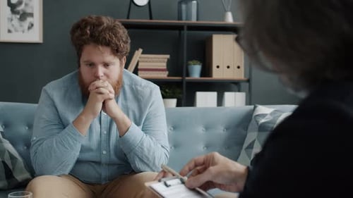 Worried and Sad Man Receiving Psychological Treatment in Therapist's Office