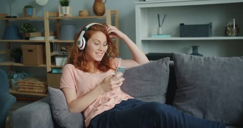 Woman Relaxing at Home with Phone and Music