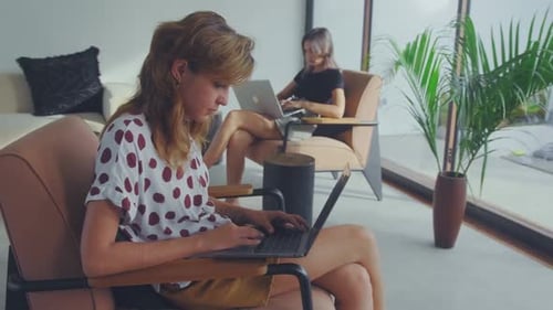 Deux collègues de travail maintiennent leur distance sociale tout en travaillant sur des ordinateurs portables