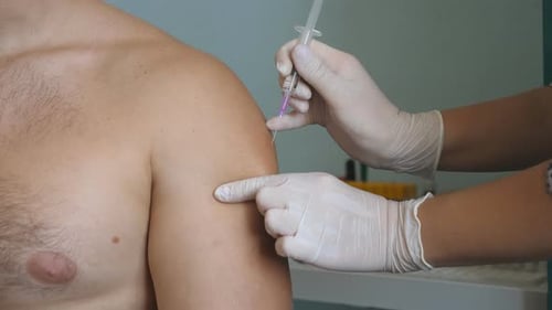 Doctor Giving Covid19 or Flu Vaccine Shot to Male Patient From Virus Disease at Health Clinic