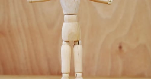 Wooden Mannequin Raising Arms on Wood Background