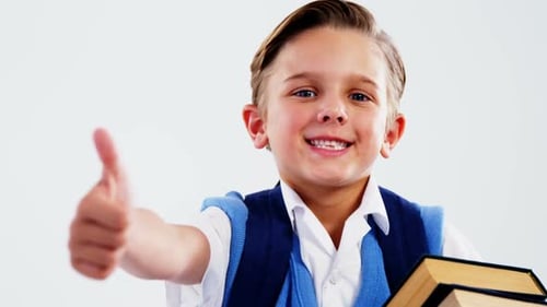 Smiling Schoolboy Giving Thumbs Up with Books