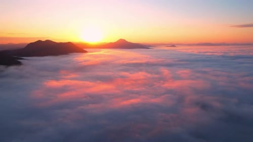 4K Scenic flight over beautiful mountain scape with bright sky and clouds
