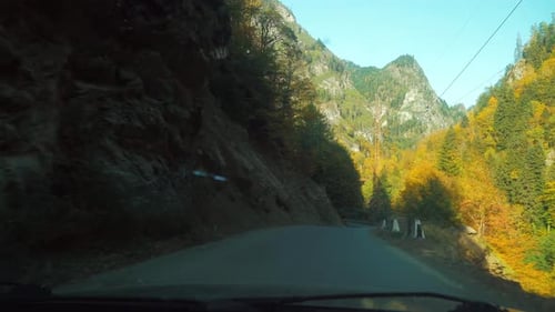 camera shoots from first person, car is driving along a narrow mountain road.