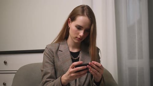 Woman playing game on smartphone indoors, close-up
