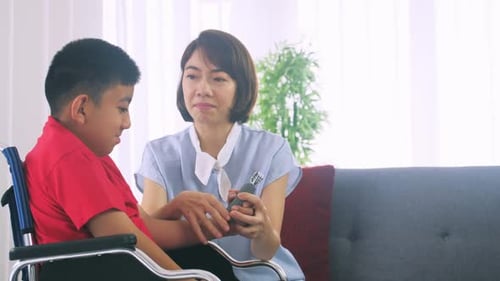 Woman Assists Child with Hand Grip Exercise at Home