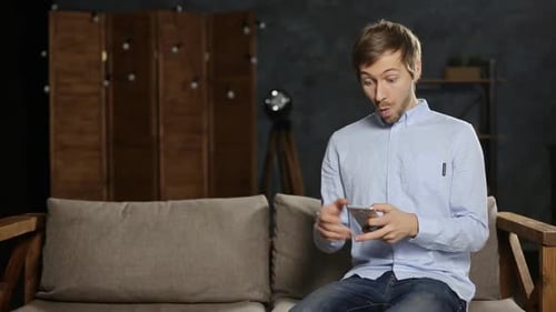 Man Sees Good News on Mobile Phone
