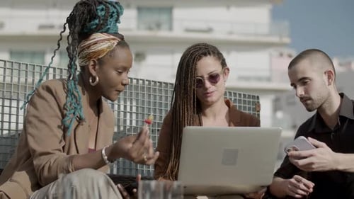 Front View of Coworkers Looking at Laptop Screen Outdoor
