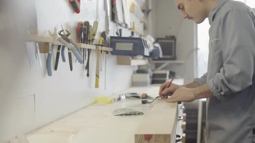 Skilled Woodworker Drawing Line on Wood Blank with Square Ruler