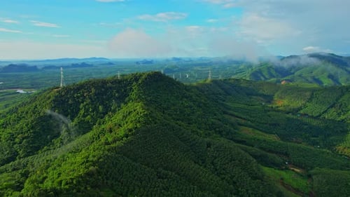 Drone flying over over telecommunication towers on green mountain