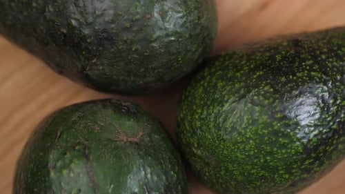 Green Avocados Spinning On Cutting Board 01