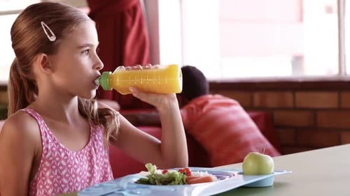 Girl Drinking Juice at School Lunch Table
