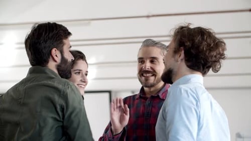 Colleagues Celebrate Achievement with High Five in Workplace