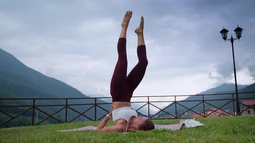 Une femme en position de Sarvangasana pratique le yoga dans la nature, le fitness et l'entraînement