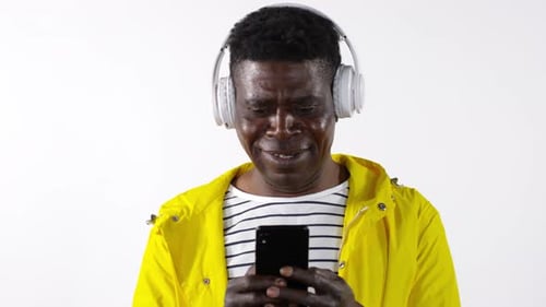 Adult Listens on Phone Wearing Headphones Indoors